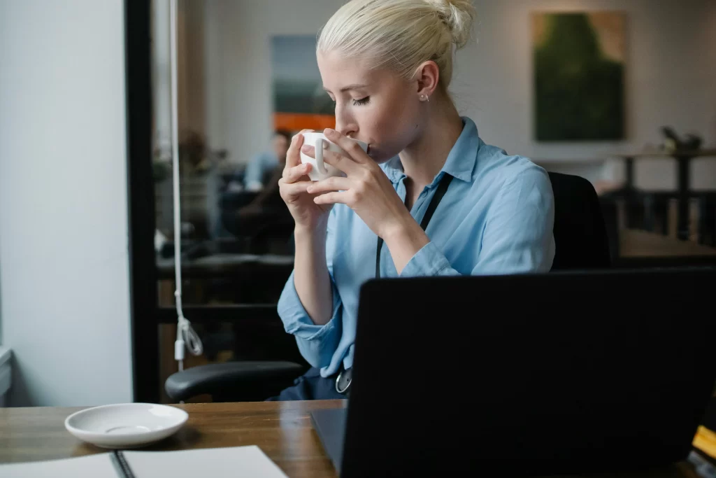 Persona tomando café mientras trabaja